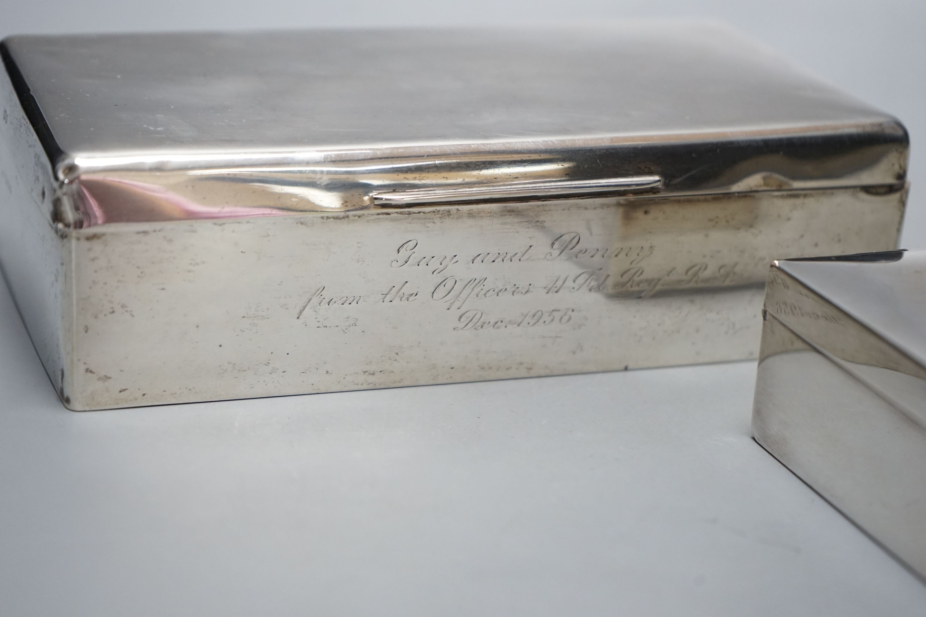 A 1950's silver mounted silver cigarette box, 18.2cm and a silver plated cigarette box.
